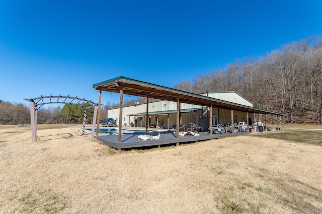 exterior space featuring a swimming pool and a lawn