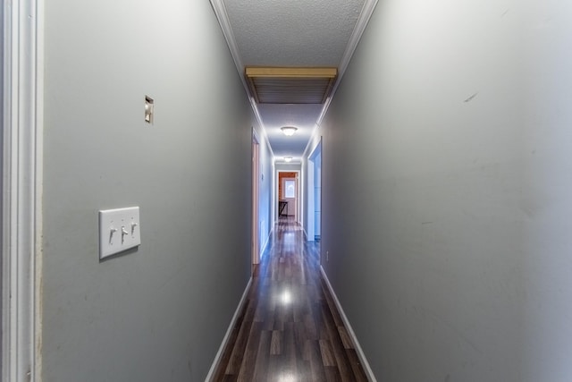 corridor featuring ornamental molding, dark hardwood / wood-style floors, and a textured ceiling