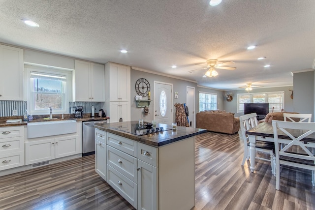 kitchen with black electric stovetop, stainless steel dishwasher, sink, and white cabinets