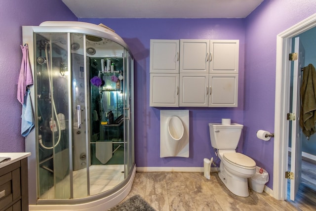 bathroom featuring vanity, a shower with shower door, and toilet