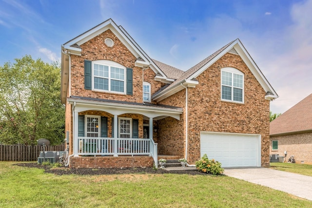 front of property with a garage, a front yard, central air condition unit, and a porch