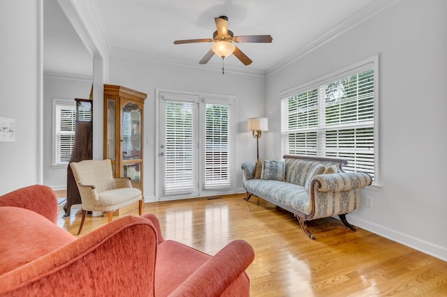 living room with ceiling fan, ornamental molding, light hardwood / wood-style floors, and plenty of natural light