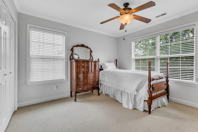 bedroom featuring light carpet, ornamental molding, and a closet