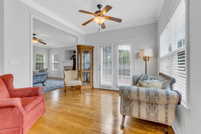 living room featuring ornamental molding, a healthy amount of sunlight, and light hardwood / wood-style floors