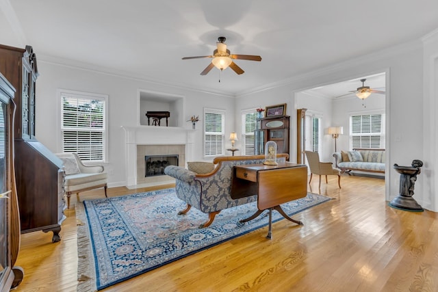 living room with ornamental molding, light hardwood / wood-style floors, and a tile fireplace