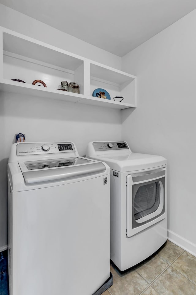 laundry area featuring light tile patterned floors and washer and clothes dryer