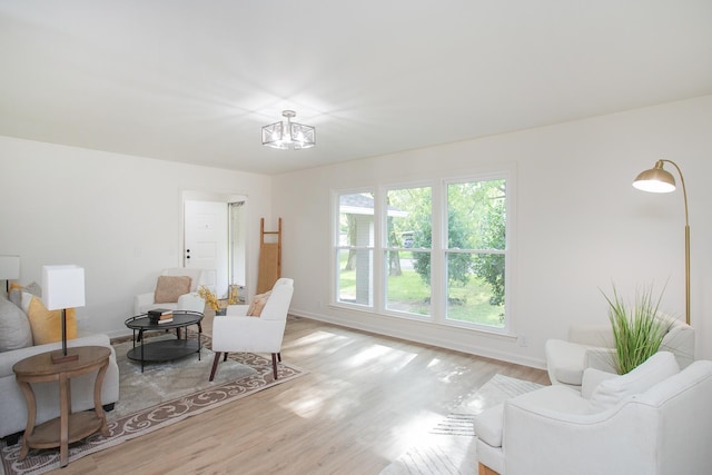 living area featuring light hardwood / wood-style floors and a chandelier