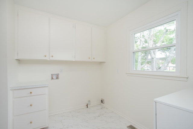 clothes washing area featuring gas dryer hookup, hookup for a washing machine, and cabinets