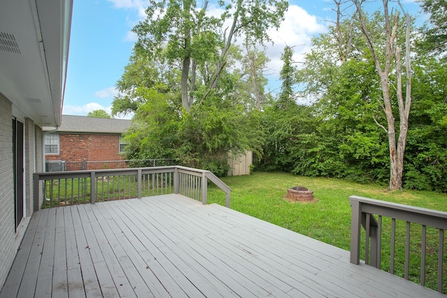 wooden terrace with a yard and an outdoor fire pit