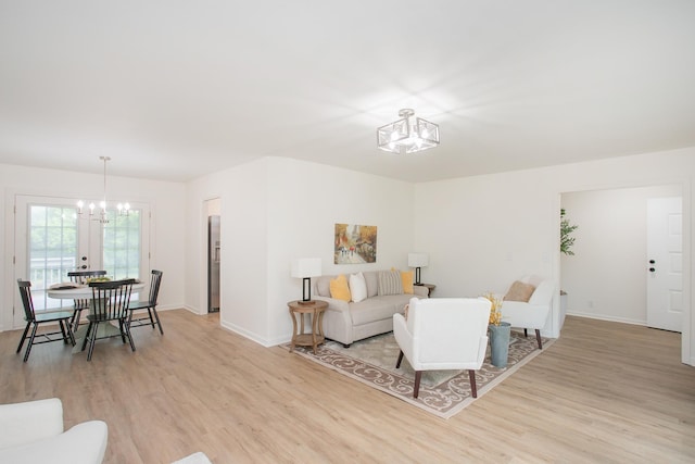 living room featuring an inviting chandelier and light hardwood / wood-style floors