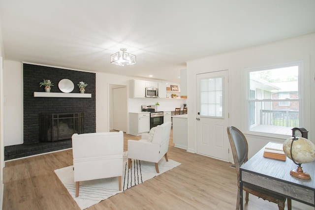 dining area featuring light wood-type flooring and a fireplace