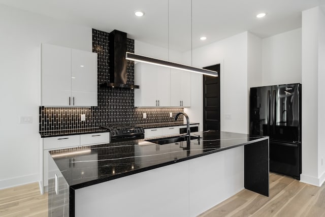 kitchen with white cabinets, wall chimney exhaust hood, sink, and black appliances