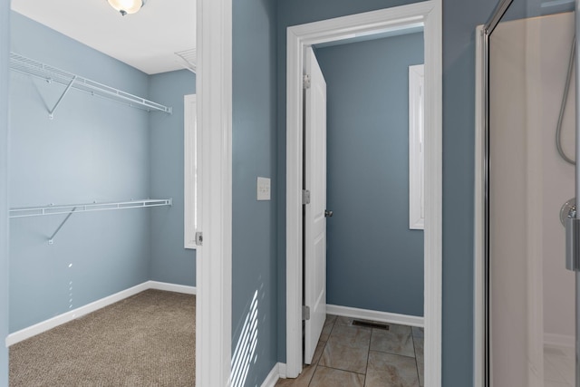 spacious closet featuring light colored carpet