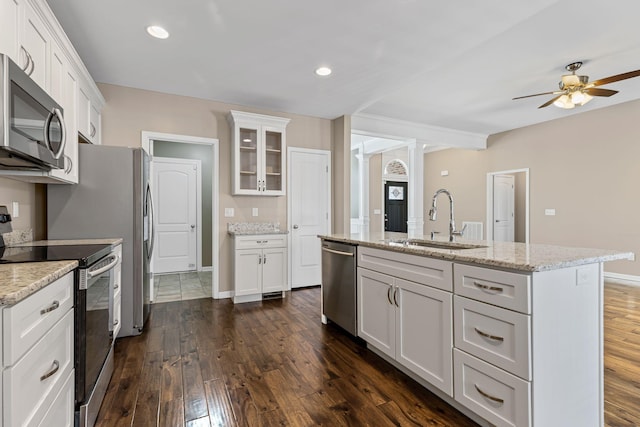 kitchen with white cabinetry, stainless steel appliances, light stone countertops, and sink