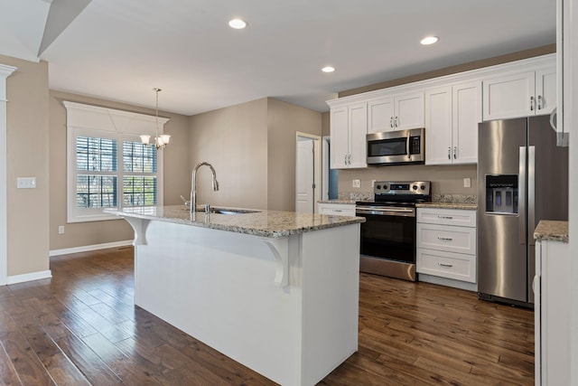 kitchen featuring sink, stainless steel appliances, white cabinets, and a center island with sink