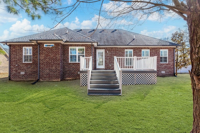 rear view of house featuring a wooden deck and a lawn