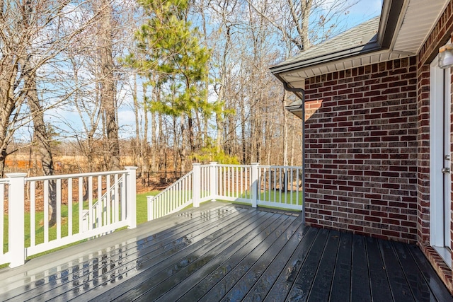 wooden deck featuring a lawn