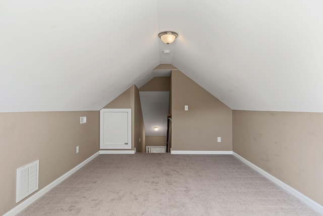 additional living space with lofted ceiling and light carpet