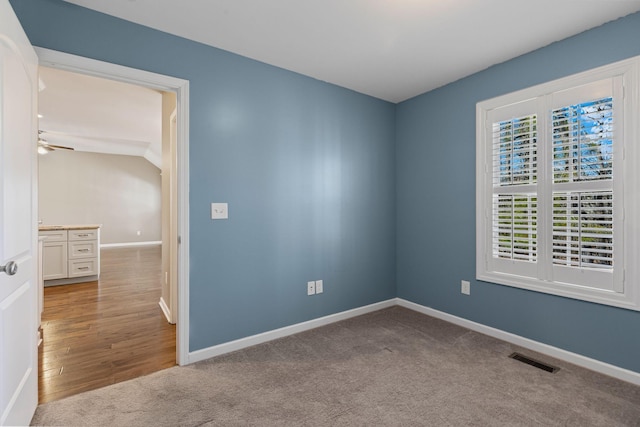 unfurnished room featuring light colored carpet and ceiling fan