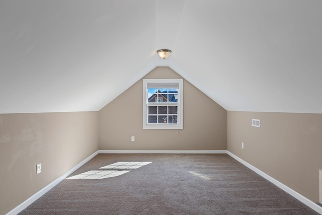 additional living space featuring vaulted ceiling and carpet