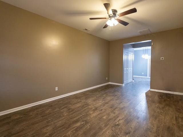 empty room with ceiling fan and dark hardwood / wood-style flooring