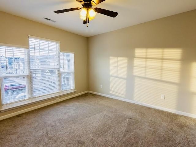 carpeted spare room with ceiling fan