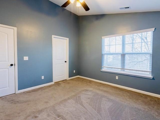 carpeted spare room featuring lofted ceiling and ceiling fan