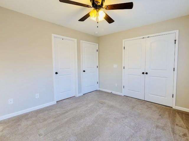 unfurnished bedroom featuring light carpet and ceiling fan