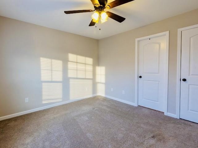 carpeted spare room with ceiling fan