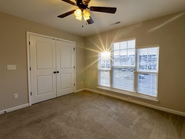 unfurnished bedroom with carpet, ceiling fan, and a closet