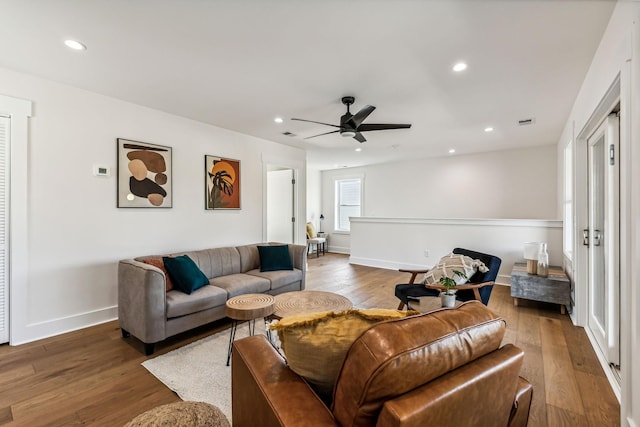 living room with wood-type flooring and ceiling fan