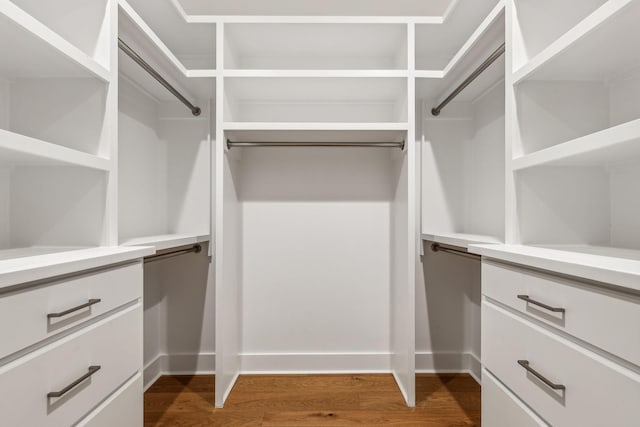 walk in closet with dark wood-type flooring