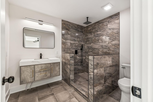 bathroom with vanity, tiled shower, and toilet