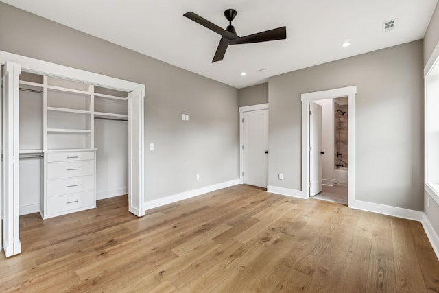 unfurnished bedroom featuring ceiling fan, two closets, connected bathroom, and light wood-type flooring