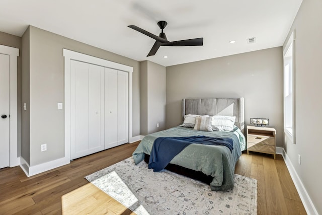 bedroom with hardwood / wood-style flooring, ceiling fan, and a closet