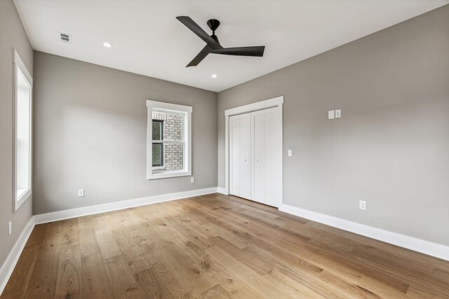 unfurnished bedroom with ceiling fan, a closet, and light wood-type flooring