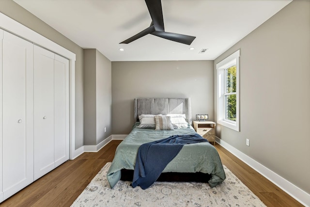 bedroom featuring hardwood / wood-style flooring, ceiling fan, and a closet