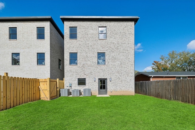 back of house featuring cooling unit and a lawn