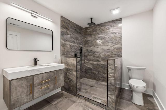 bathroom featuring vanity, tiled shower, and toilet