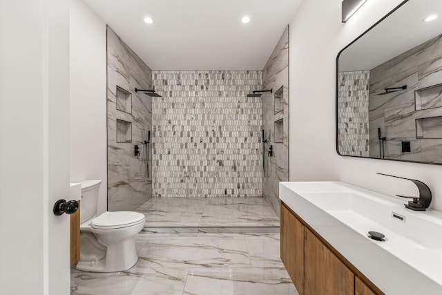 bathroom featuring vanity, toilet, and a tile shower