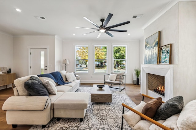 living room with crown molding, ceiling fan, and light hardwood / wood-style flooring