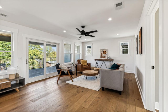 sitting room with plenty of natural light, dark wood-type flooring, and ceiling fan