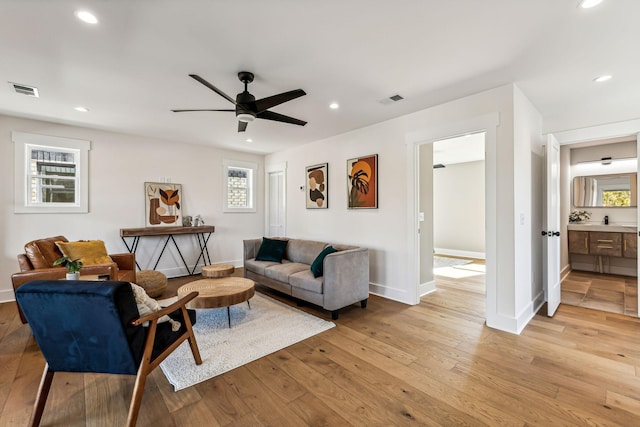 living room with light hardwood / wood-style flooring and ceiling fan