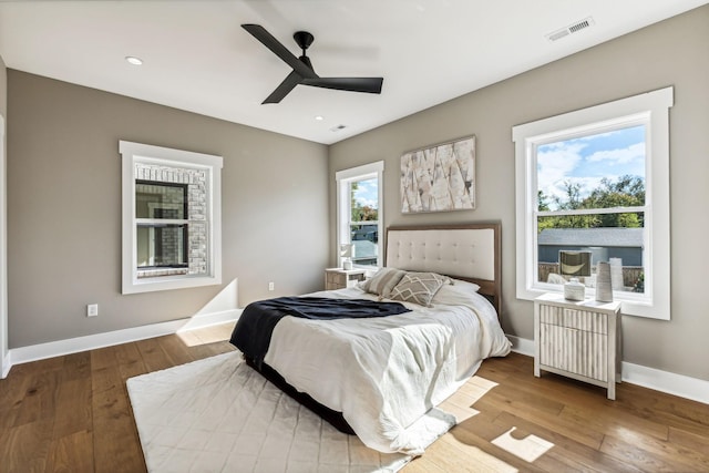 bedroom with radiator, light hardwood / wood-style floors, and ceiling fan