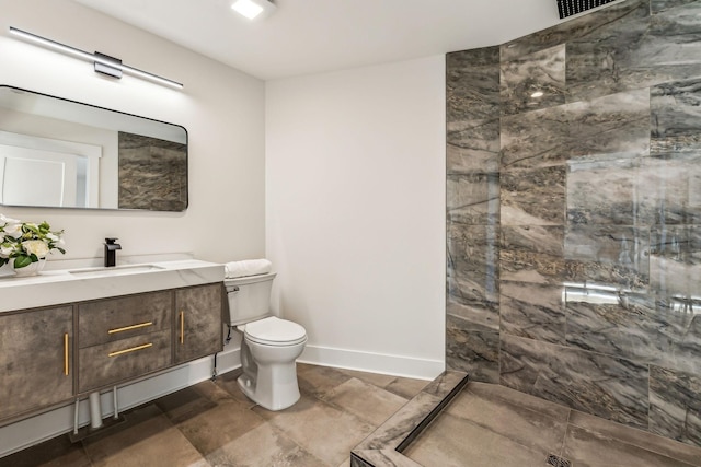 bathroom featuring vanity, toilet, and tiled shower