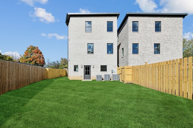 rear view of house with a yard and central air condition unit