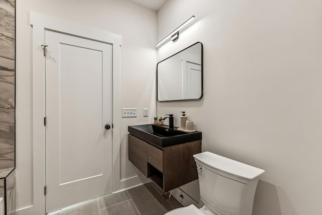 bathroom featuring vanity, tile patterned flooring, and toilet