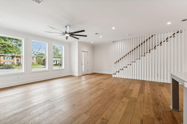 unfurnished living room with ornamental molding, light hardwood / wood-style floors, and ceiling fan