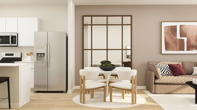 kitchen with stainless steel appliances, white cabinets, and light wood-type flooring