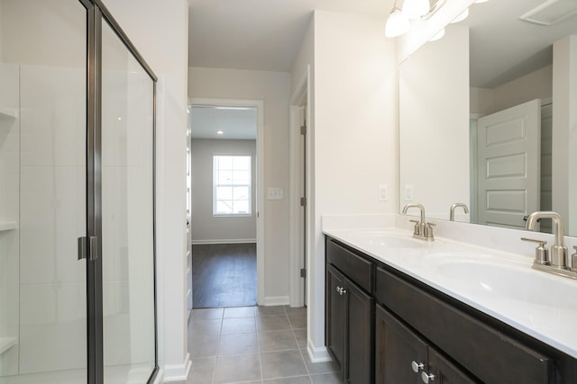 bathroom with walk in shower, vanity, and tile patterned flooring